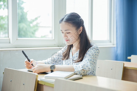 大学生写字清新文艺女孩教室里写作业背景