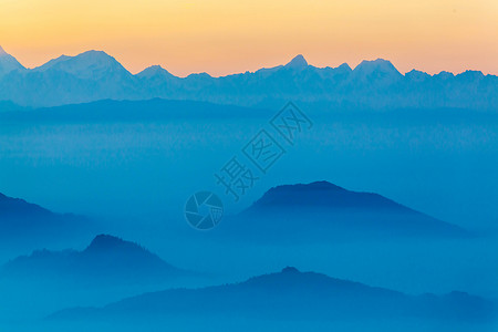 层叠的山山间日落背景