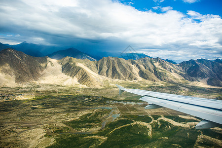 光翅膀低空飞过雅鲁藏布江上空的客机背景