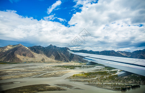 飞过蓝天的客机低空飞过雅鲁藏布江上空的客机背景