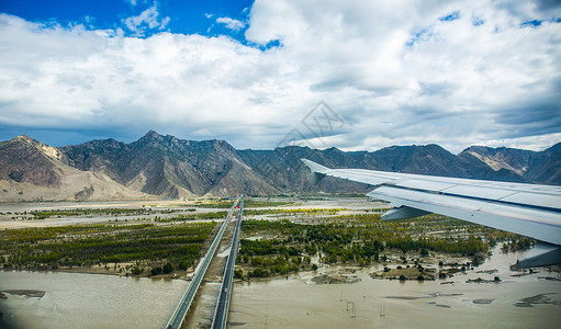 飞过蓝天的客机低空飞过雅鲁藏布江上空的客机背景