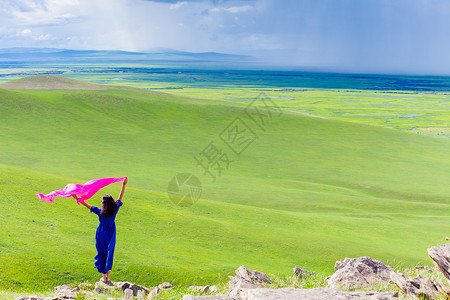 蓝色丝巾草原上美女手中丝巾飘扬背景