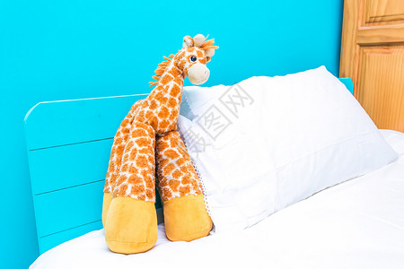温馨卡通床边的长颈鹿玩偶背景
