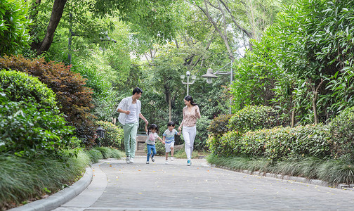 年轻父母带孩子小区散步运动高清图片