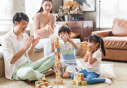 棋牌游戏人物年轻父母陪孩子在家玩游戏背景
