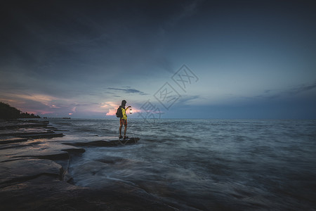 五彩滩日落涠洲岛海边手拿马灯的人背景