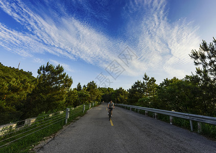 在路唯美素材在公路上骑车的男子背景