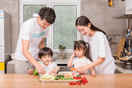 年轻父母与孩子一起在厨房做饭背景图片