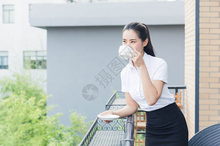 阳台女美丽职业女性阳台放松喝咖啡背景