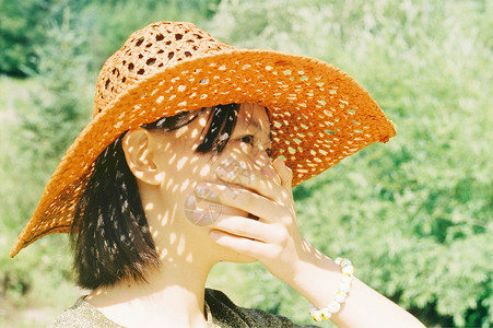 太阳帽子戴帽子捂嘴的女孩儿背景