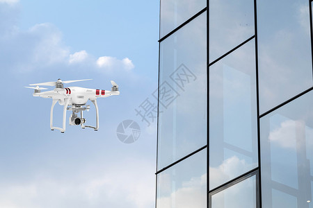 大楼玻璃天空中的无人机设计图片