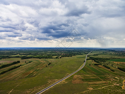 航拍多云天气下的草原天路背景图片