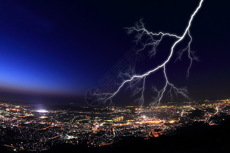 城市夜晚灯光城市上空的闪电设计图片