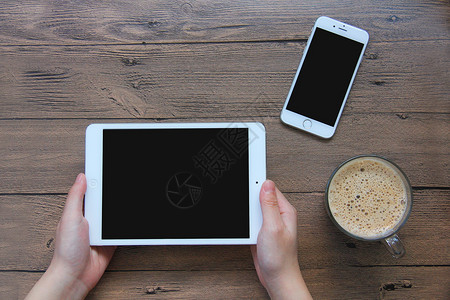 现代生活桌面手拿ipad玩游戏 咖啡手机素材背景