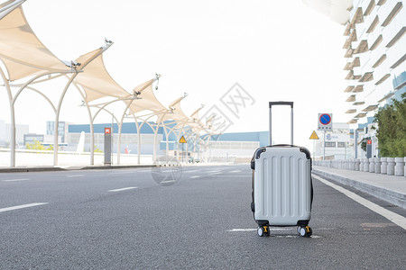 旅游行李放在马路中间的白色行李箱背景