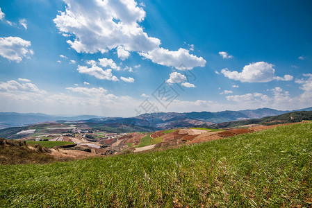 云南东川红土地-蓝天白云红色山丘背景图片