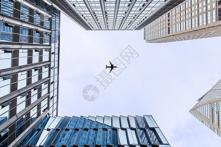 飞机飞过城市背景图片