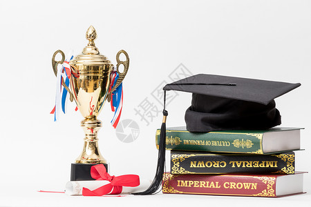 线上毕业典礼学士帽和冠军奖杯组合摄影图背景
