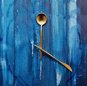 黄铜钟刀叉勺蓝色背景时间钟厨具背景