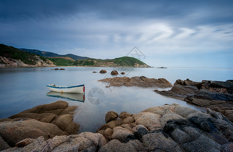 插画海滩背景蓝天白云下的岩石小船背景