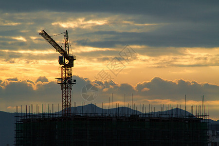 日出时的建筑工地塔吊高清图片