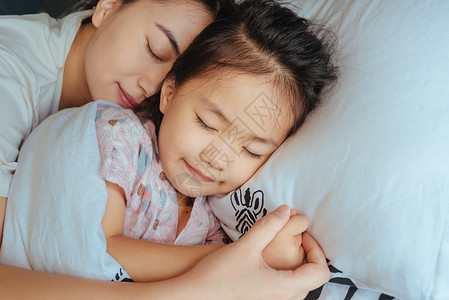 温馨家庭卧室母子拥抱入眠高清图片