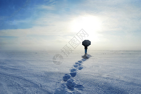 在雪上行走的人物背影背景图片