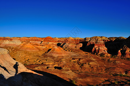 新疆五彩城夕阳下的彩色山丘与摄影师剪影背景