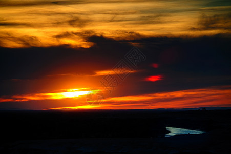 光线散射新疆五彩滩的日落与湖泊背景