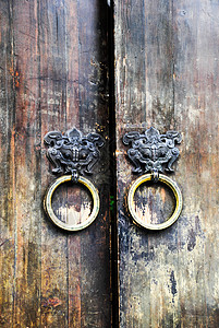古老的木门老屋的铜门环背景