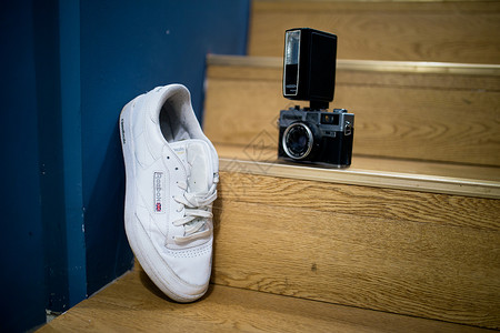 白色跑鞋运动鞋与相机背景