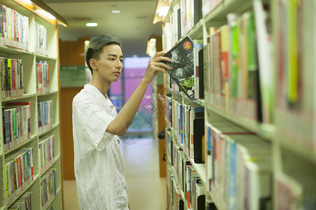 学校图书馆里男同学在认真学习看书背景图片