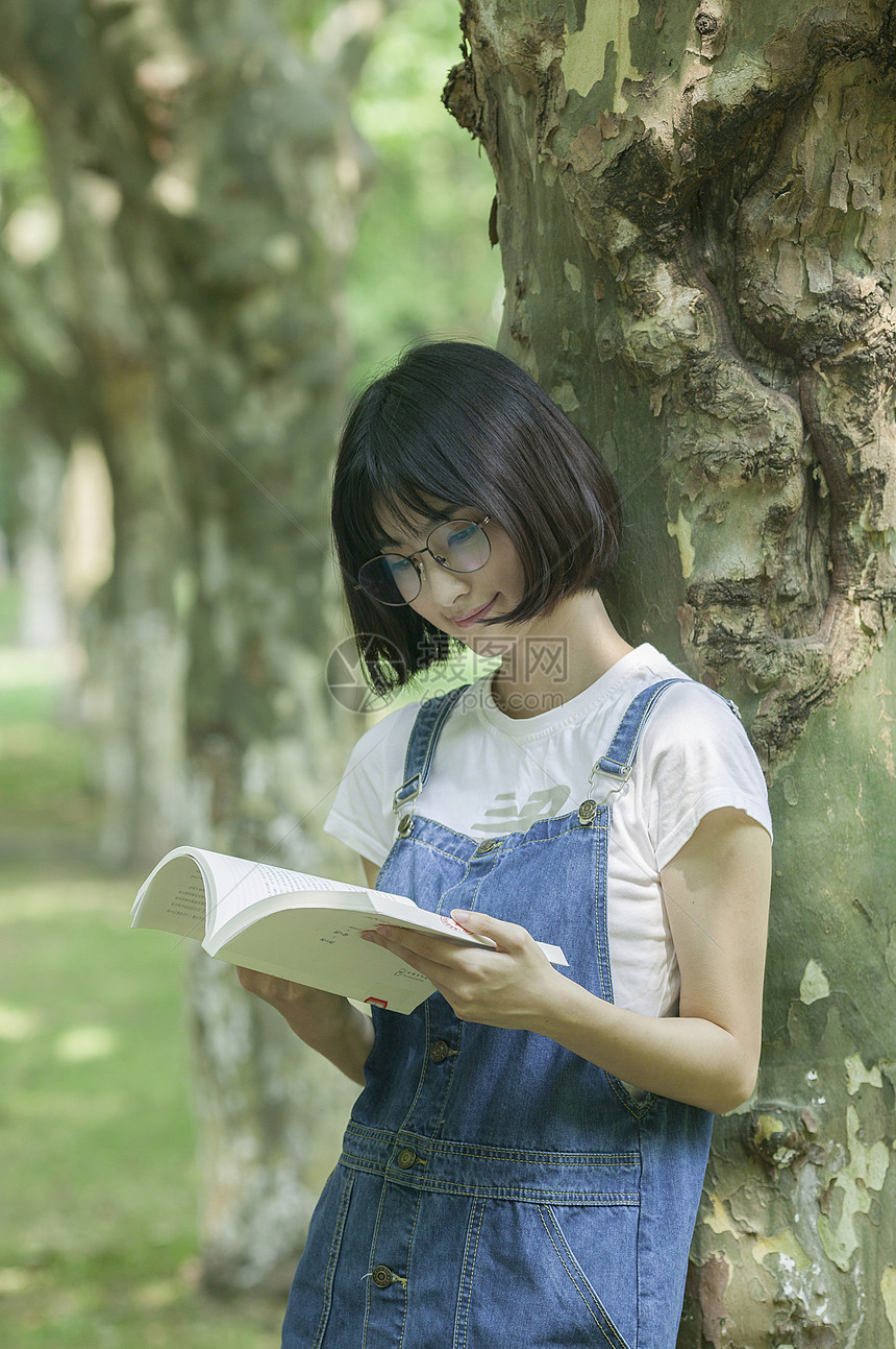 学校林荫道上女同学下课学习看书图片