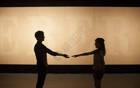 握手意境素材灯光的剪影效果是一对情侣的故事背景