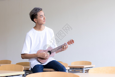 吉他教室教室里弹尤克里里的男同学背景