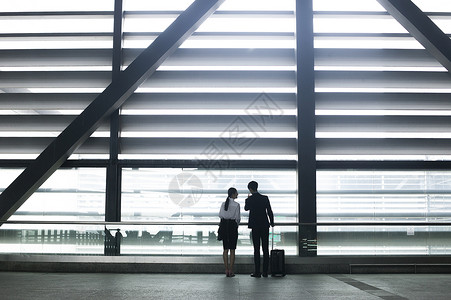 商务男士和商务女士在机场通道会晤握手图片