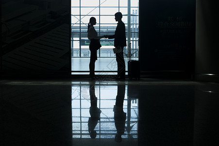 商务男士女士在机场见面会晤握手图片