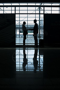 商务男士女士在机场见面会晤握手高清图片