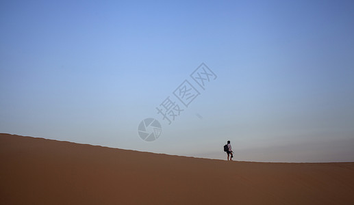 走在沙漠上的人旅行中一个人孤独的在沙漠上行走背景