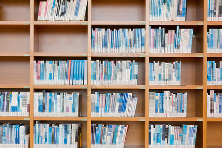 图书馆书架上排列整齐的书背景图片