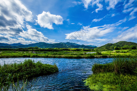 草原流水蓝天下的绿色山峦和草地背景