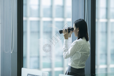 看着远方商业大厦商务女士正在用望远镜看着目标背景