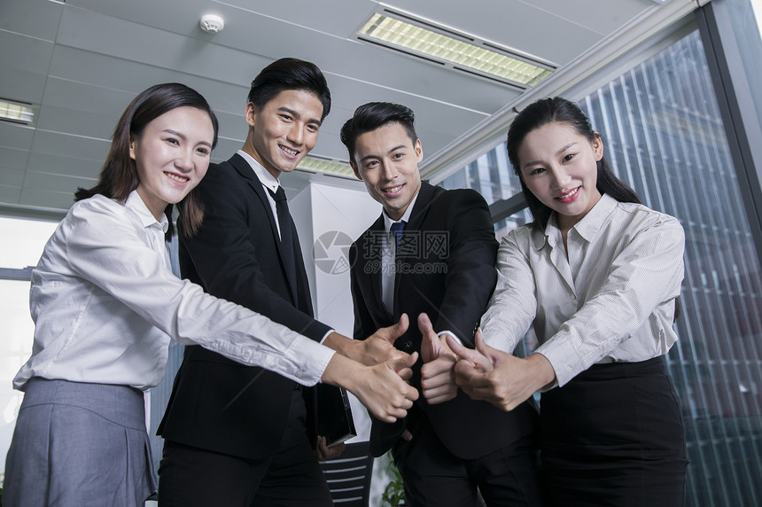 商务团队竖起拇指表达合作成功的信念图片