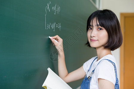 自考毕业正在教室黑板写板书的女生背景