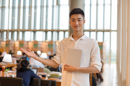 拿花男生素材同学图书馆拿着书欢迎大家背景