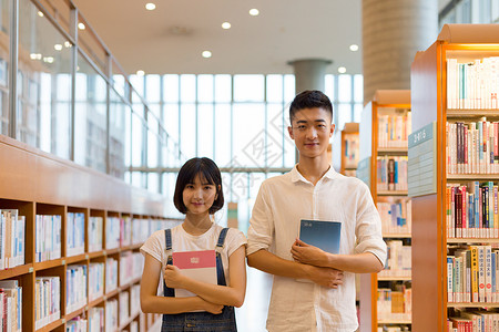 男女大学生青春男女同学在图书馆学习看书讨论背景
