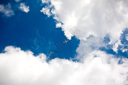一架飞机飞过蓝天白云背景图片