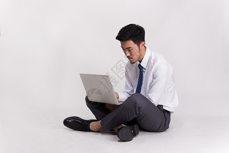 坐着操作笔记本电脑的商务人士图片
