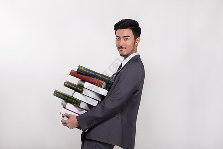 学习商务男士抱着一大堆书的商务人士背景