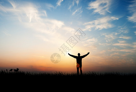 太阳下山时晚霞下张开手臂的人剪影背景图设计图片